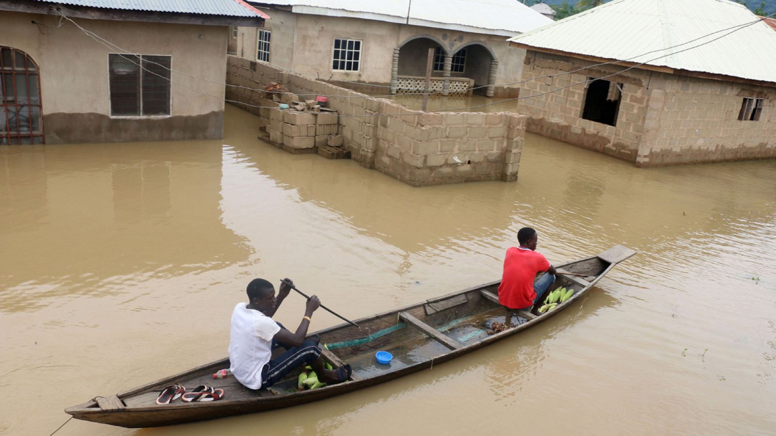 Un canoa avanza entre las casa inundadas en la ciudad de Lokoja, Nigeria