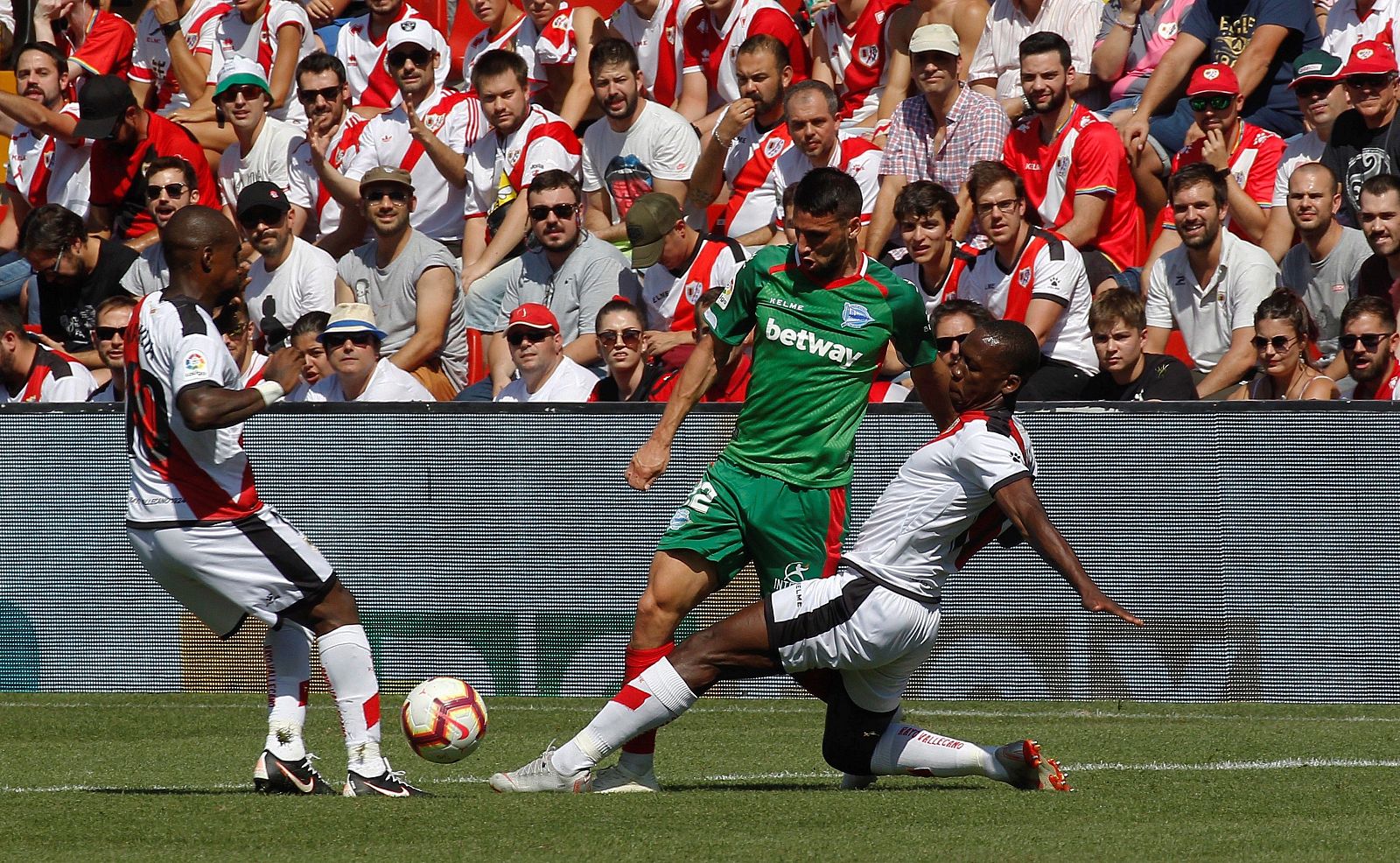 El defensa peruano del Rayo Vallecano, Luis Advíncula (d), disputa el balón con el delantero argentino del Alavés, Jonathan Calleri (c)