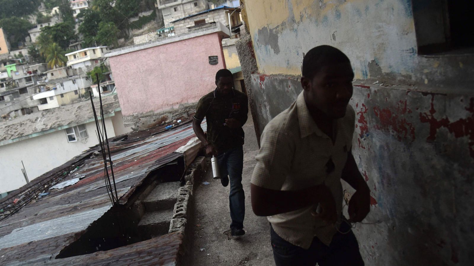 Imagen de dos hombres corriendo en la capital de Haití, Puerto Príncipe.