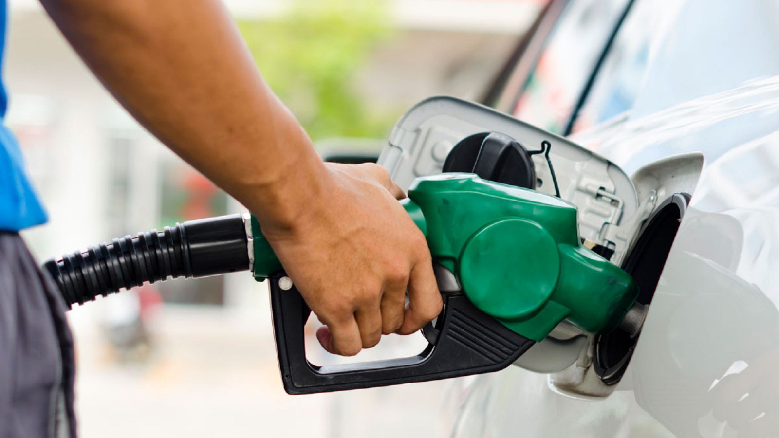 Un consumidor reposta combustible en una gasolinera