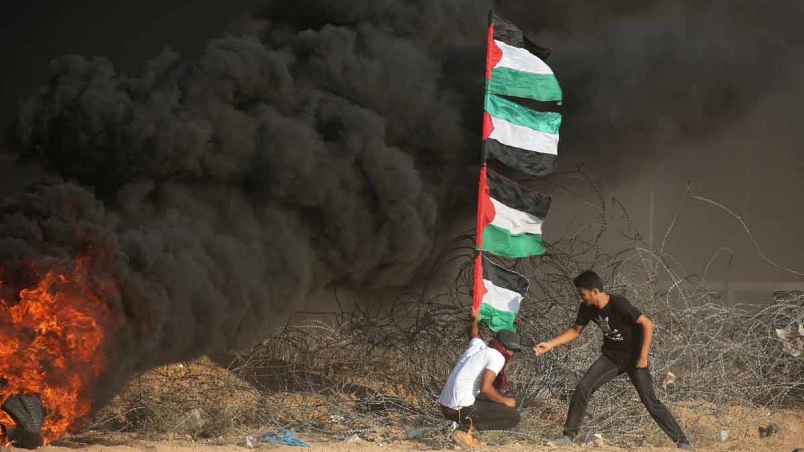 Manifestantes colocan banderas palestinas en la frontera entre Israel y Gaza durante una protesta este viernes