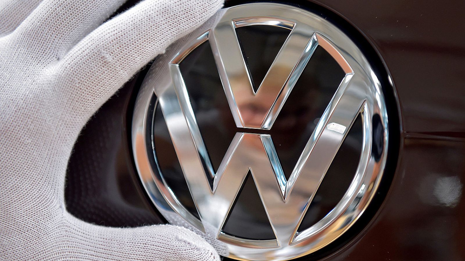 Un mecánico coloca el logotipo de Volkswagen en un modelo eléctrico e-Golf en Dresde, Alemania