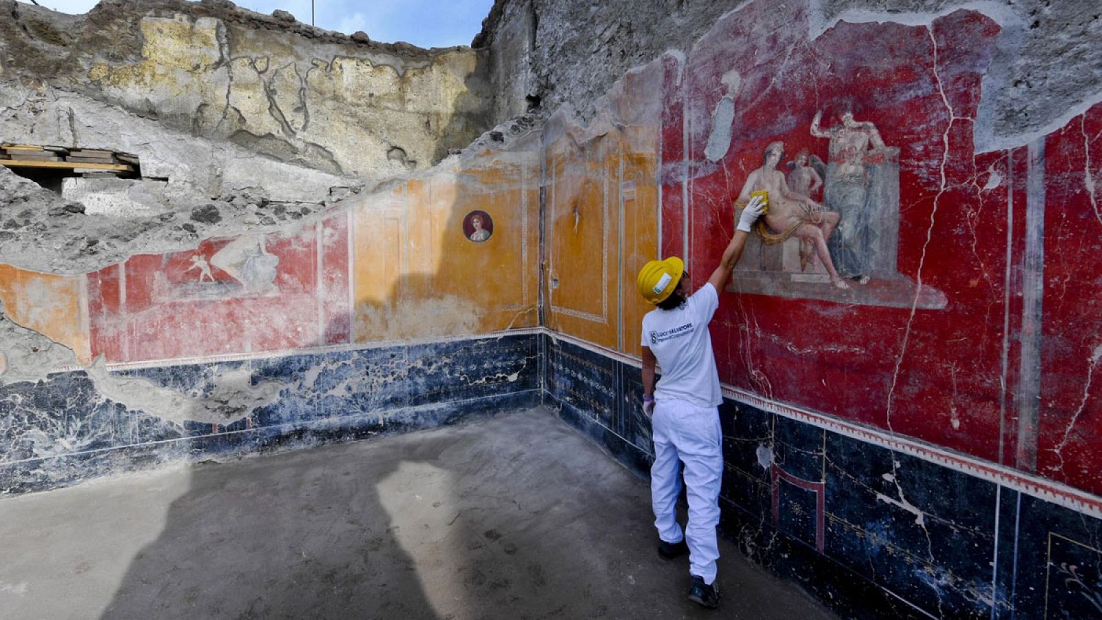 Un operario trabaja en un fresco descubierto en las nuevas excavaciones en Pompeya.