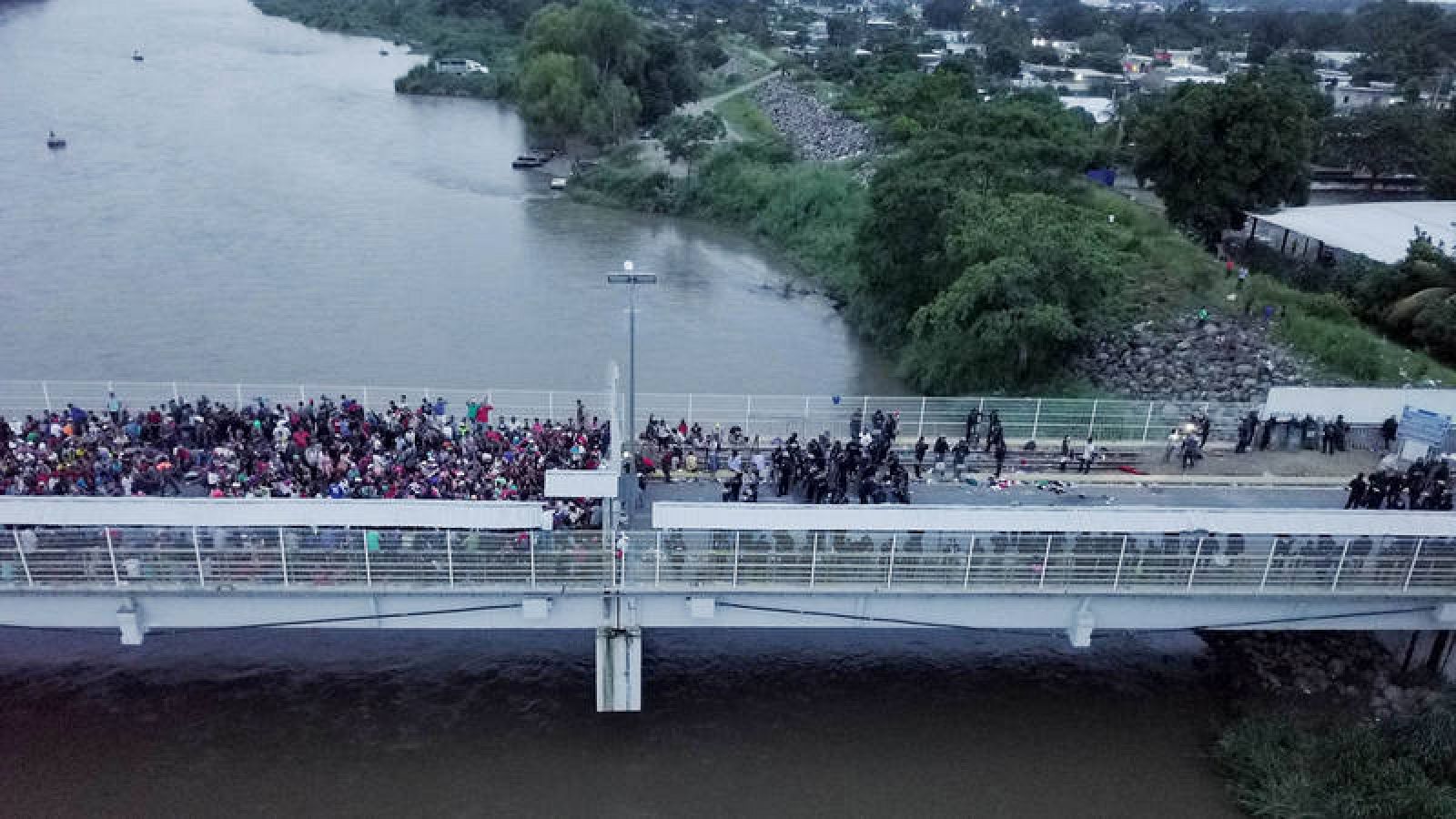 Fotografía tomada desde un dron de cientos de migrantes hondureños en uno de los puentes que atraviesa el río Suchiate