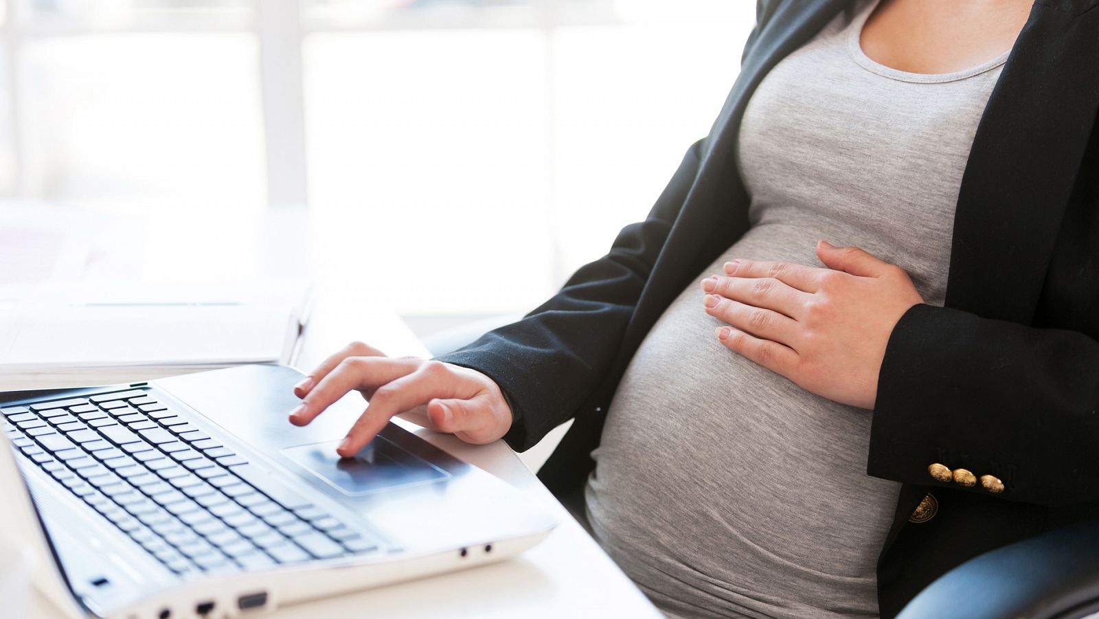 Una mujer embarazada trabaja con su ordenador