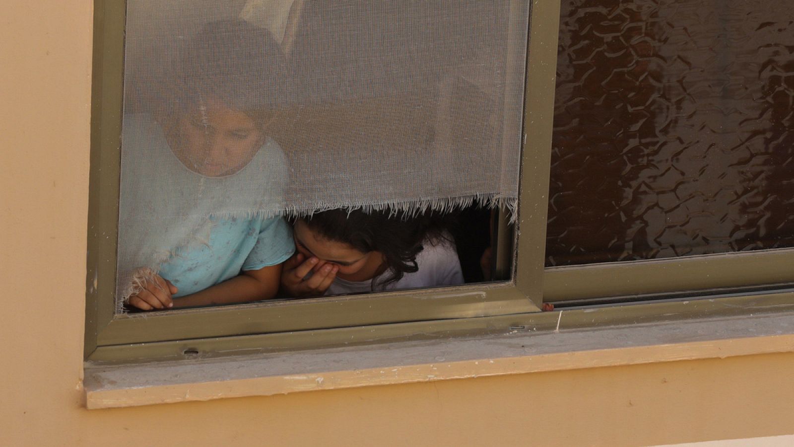 Dos niños contemplan desde una ventana el funeral de un joven palestino en la ciudad cisjordana de Tubas (24/10/2018)