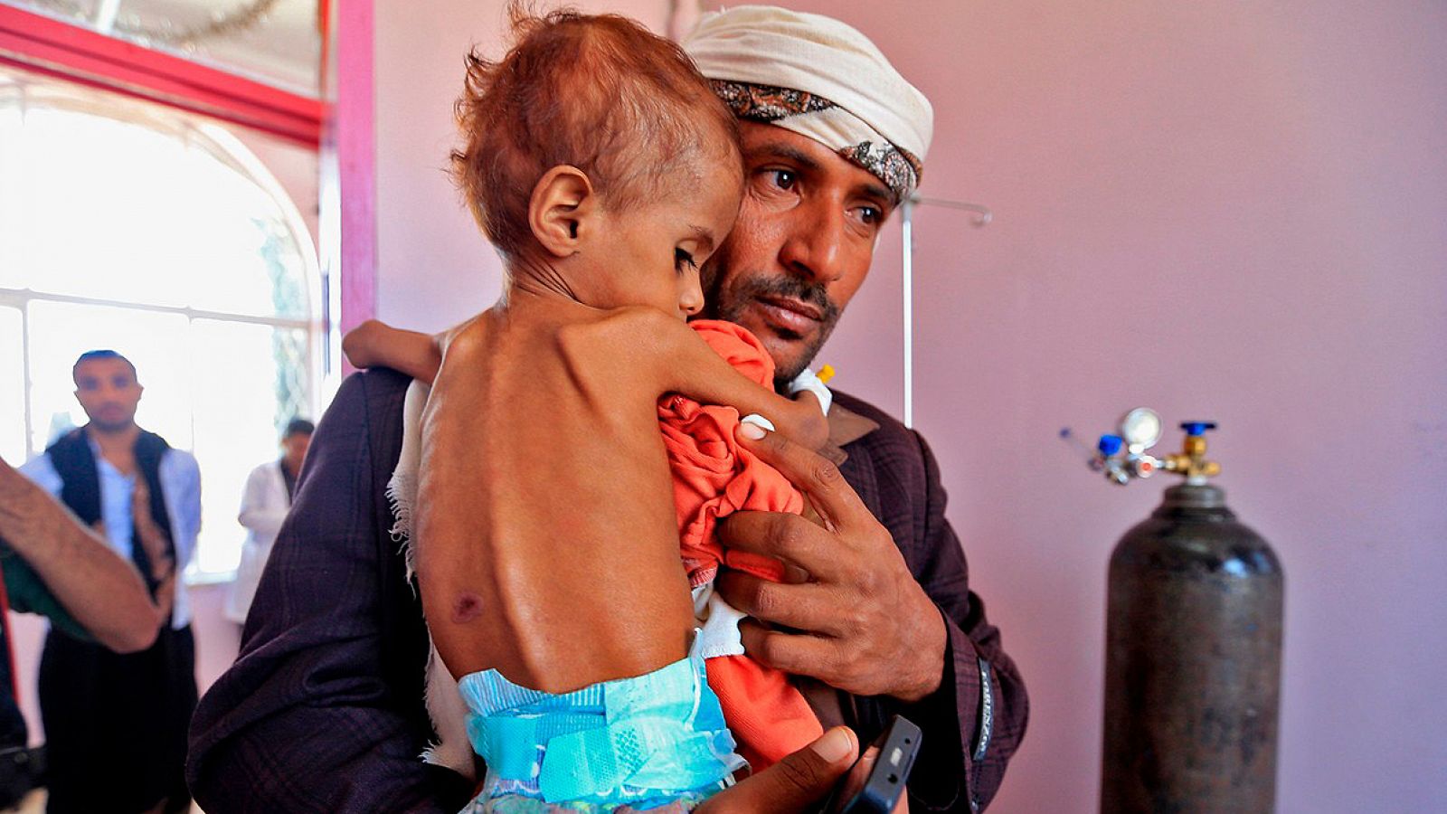 Imagen de archivo: un hombre lleva a su hijo malnutrido en brazos en un hospital de Saná, Yemen Foto: Mohammed HUWAIS / AFP