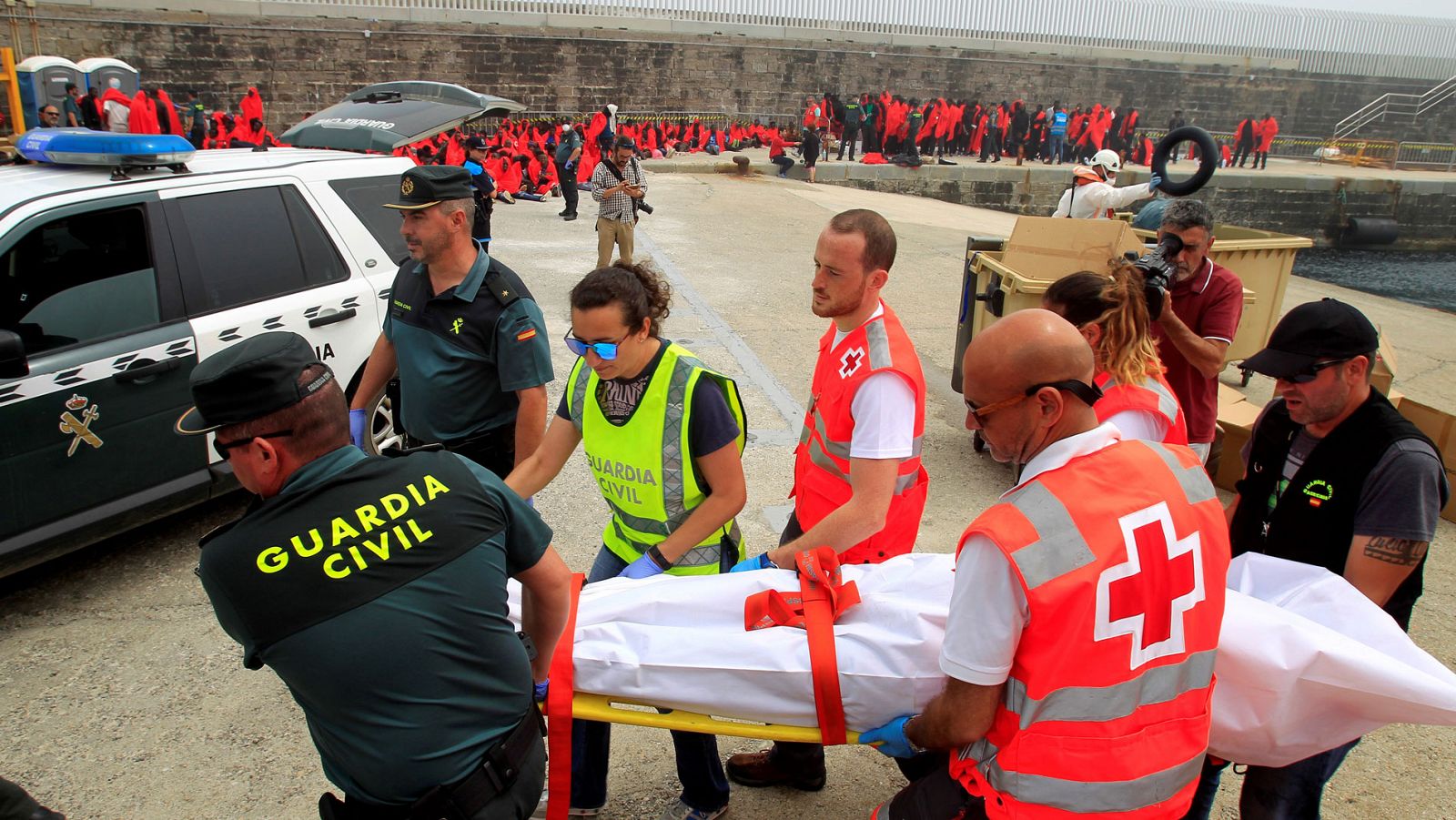 Personal de Cruz Roja y agentes de la Guardia Civil trasladan el cuerpo de un migrante fallecido en el Estrecho el pasado mes de junio