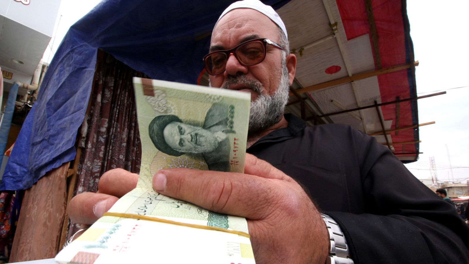 Un hombre compra riales iraníes en la ciudad iraquí de Basra antes de que entren en vigor las sanciones de EE.UU.