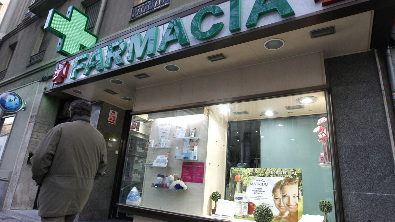 Un hombre camina ante una farmacia situada en la madrileña calle de Ríos Rosas