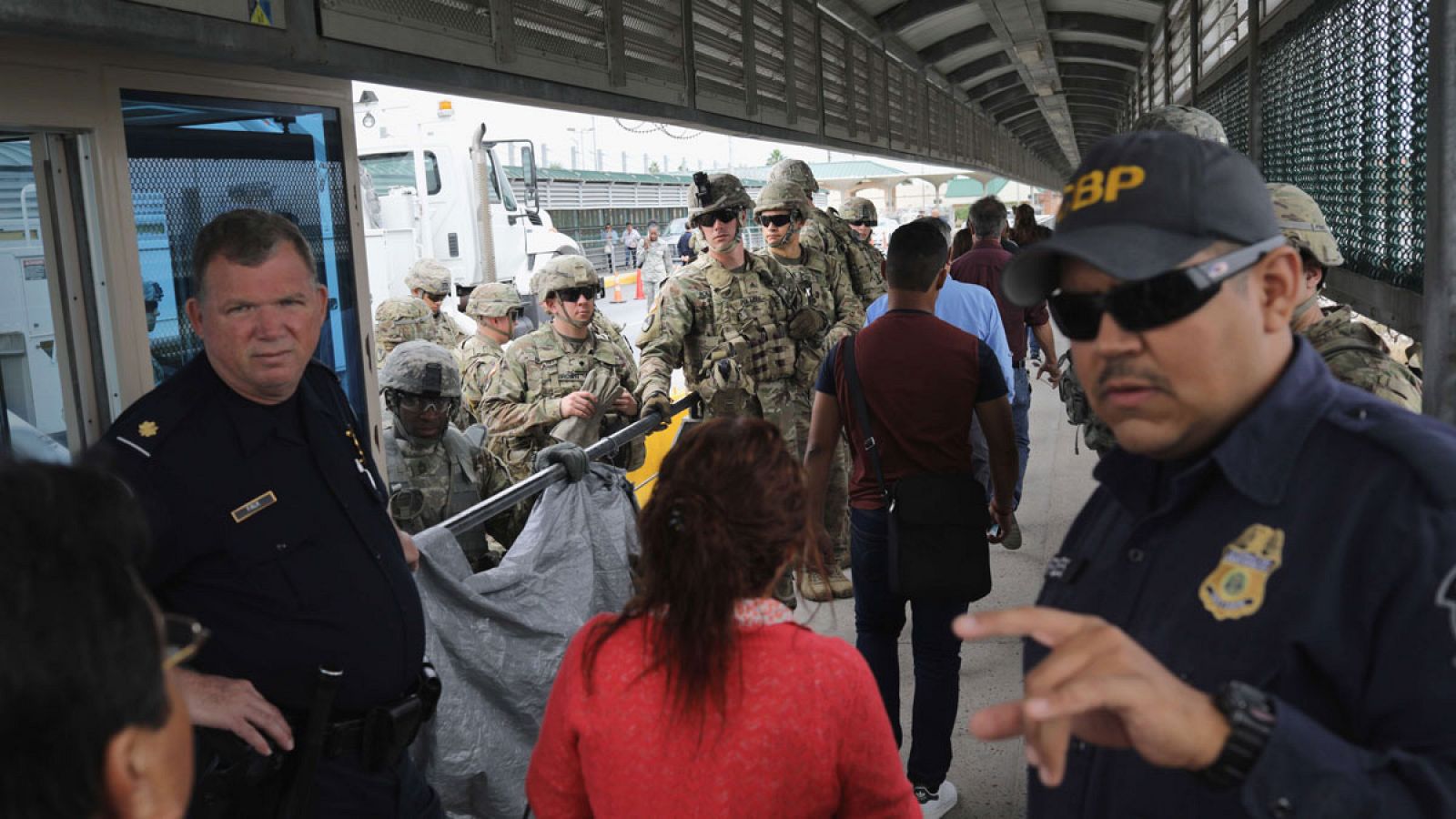 Gente pasando hacia un control de inmigración tras cruzar de Mexico a Estados Unidos.
