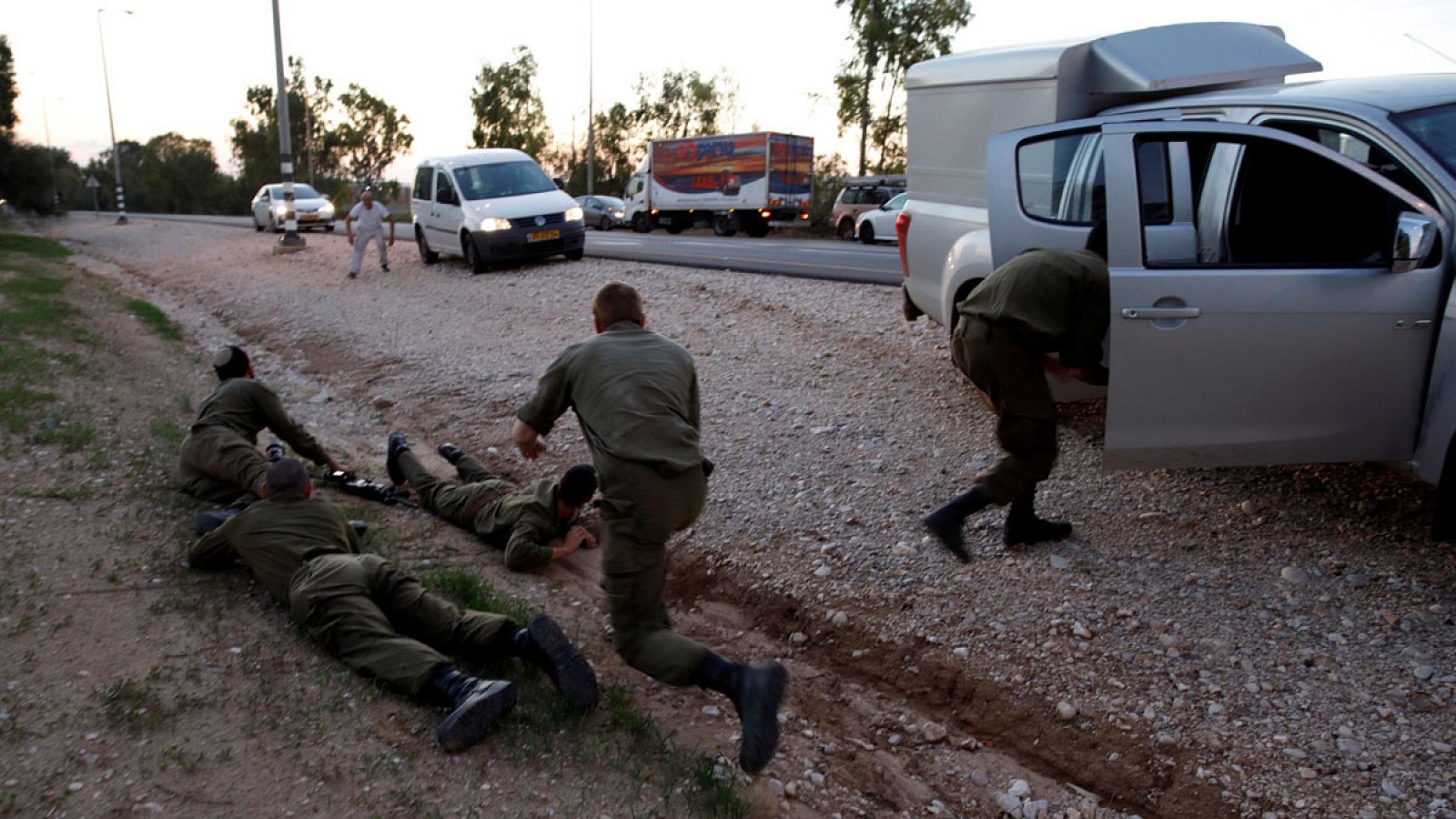 Soldados y civiles israelíes se protegen tumbándose en el suelo cuando suena la sirena de ataque aéreo.