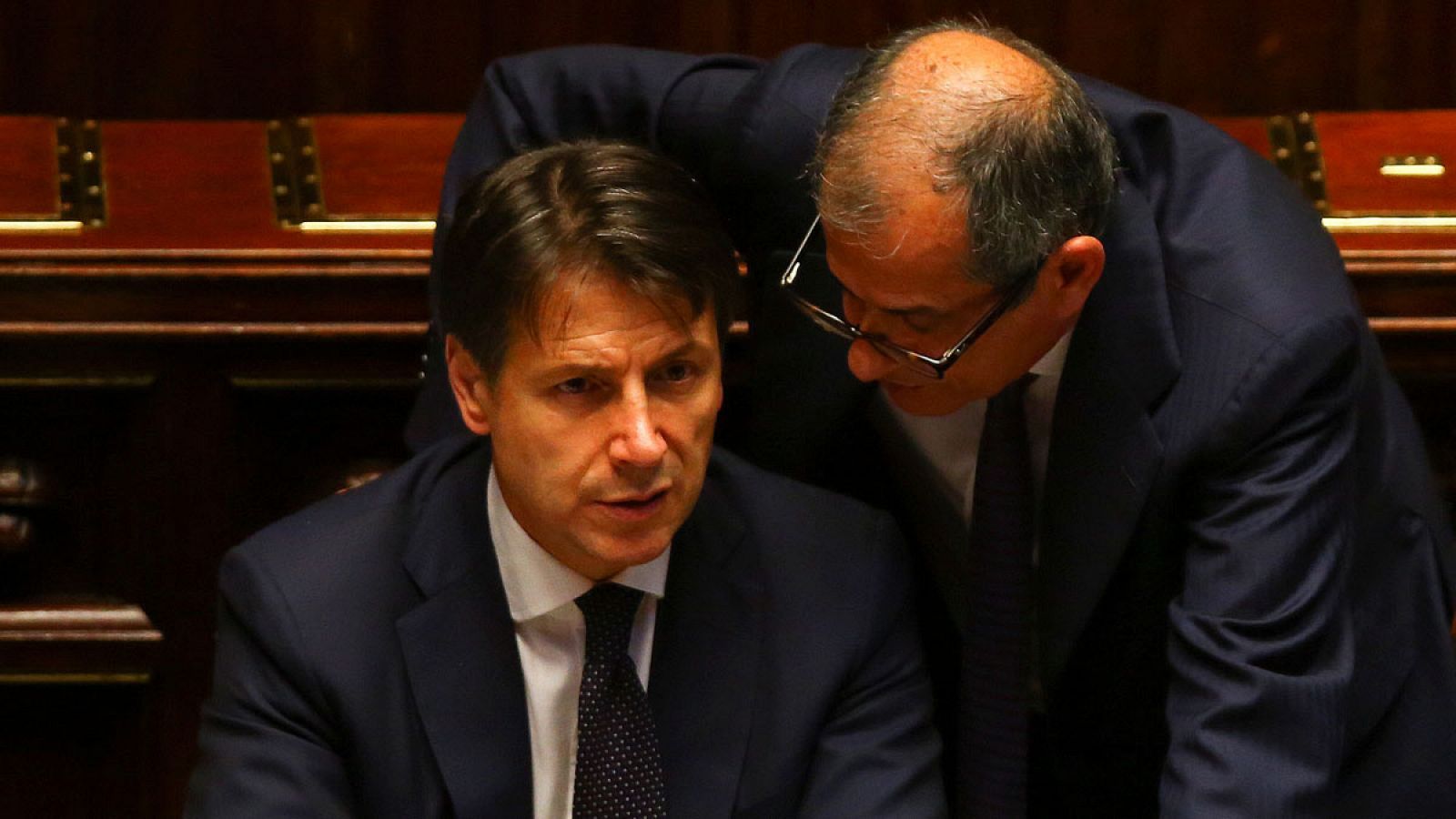 El primer ministro italiano, Giuseppe Conte, conversa con su ministro de Economía, Giovanni Tria