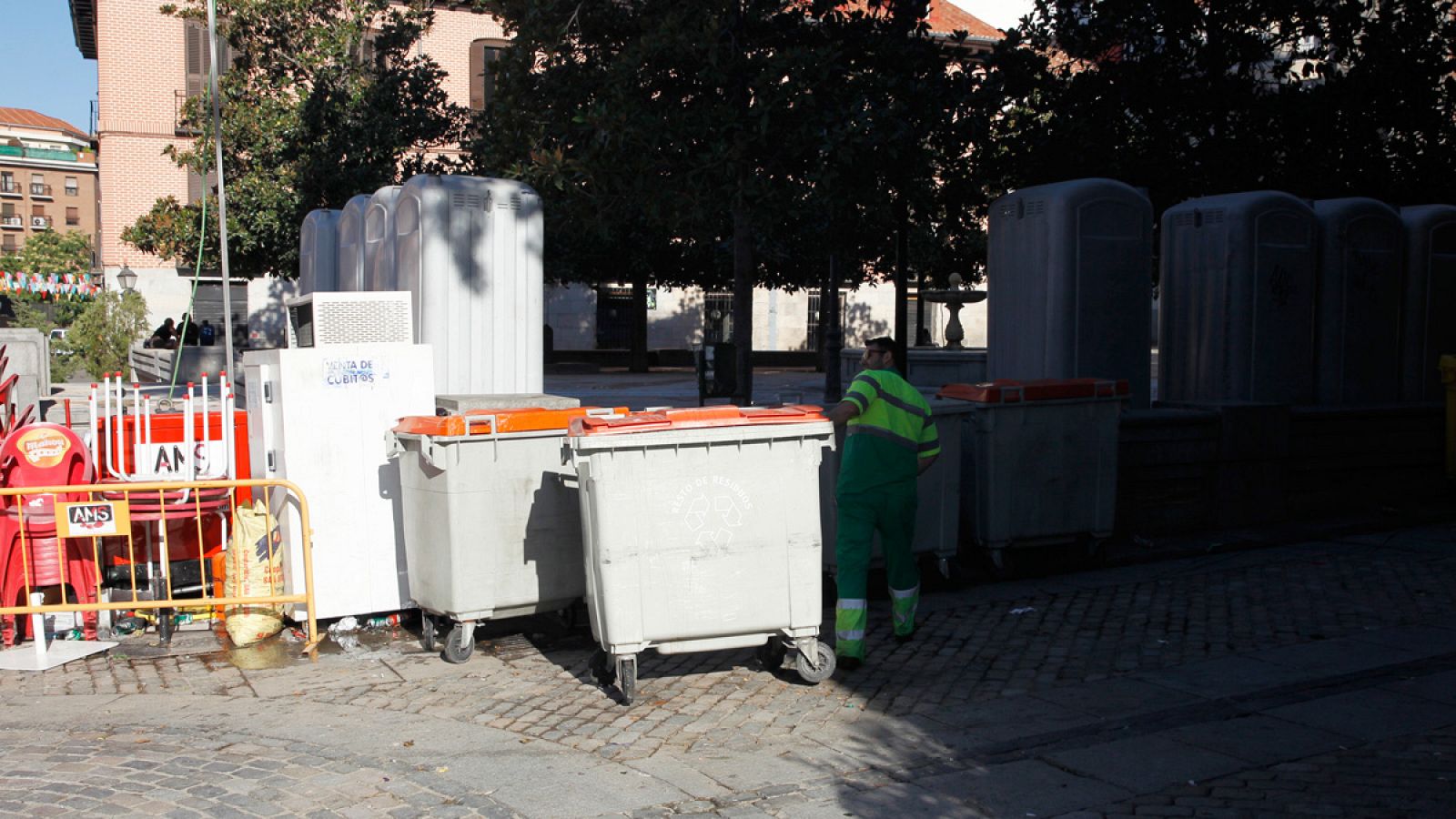 Un trabajador municipal del servicio de limpieza recoge unos contenedores de residuos en Madrid