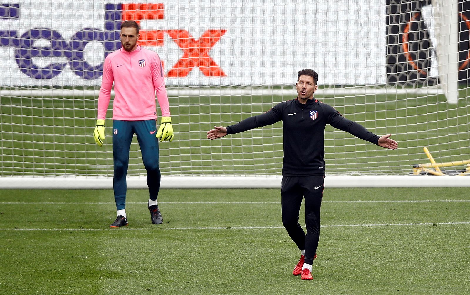 Simeone (dcha) gesticula ante el portero Oblak en un entrenamiento del Atlético