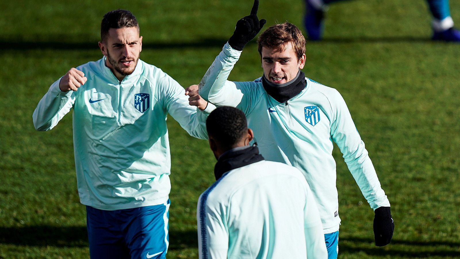 Los jugadores del Atlético de Madrid, Koke Resurrecccion, Antoine Griezmann y Thomas Lemar (de espaldas), durante el entrenamiento de la plantilla rojiblanca en la Ciudad Deportiva Wanda en Majadahonda.