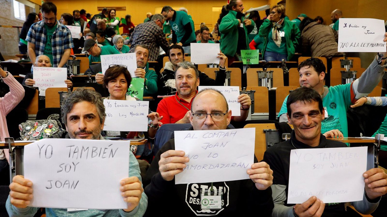Miembros de la Plataforma de Afectados por la Hipoteca (PAH) muestran carteles con el lema "Yo también soy Joan" al finalizar su asamblea estatal en Valencia. EFE/Kai Försterling