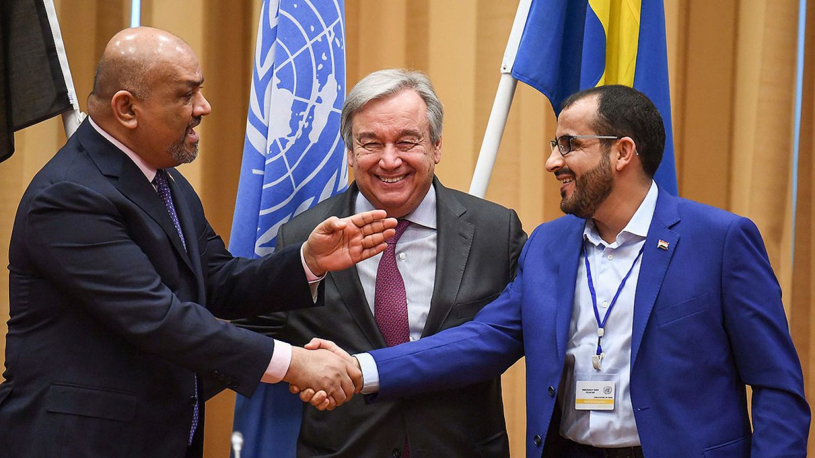 El ministro de Exteriores de Yemen (izquierda) da la mano al negociador de los rebeldes hutíes, Mohammed Abdelsalam, ante el secretario general de la ONU, Antonio Guterres, en Suecia. Jonathan NACKSTRAND / AFP