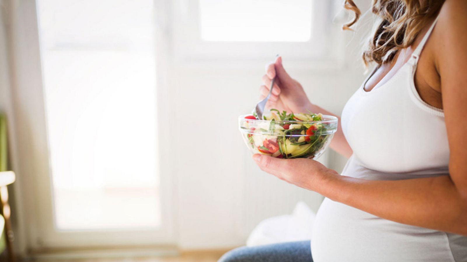 Una embarazada comiendo una ensalada