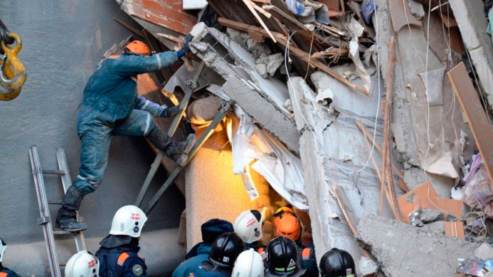 Miembros de los servicios de rescate rusos retiran escombros del edificio derrumbado en la ciudad de Magnitogorsk, en la región de los Urales