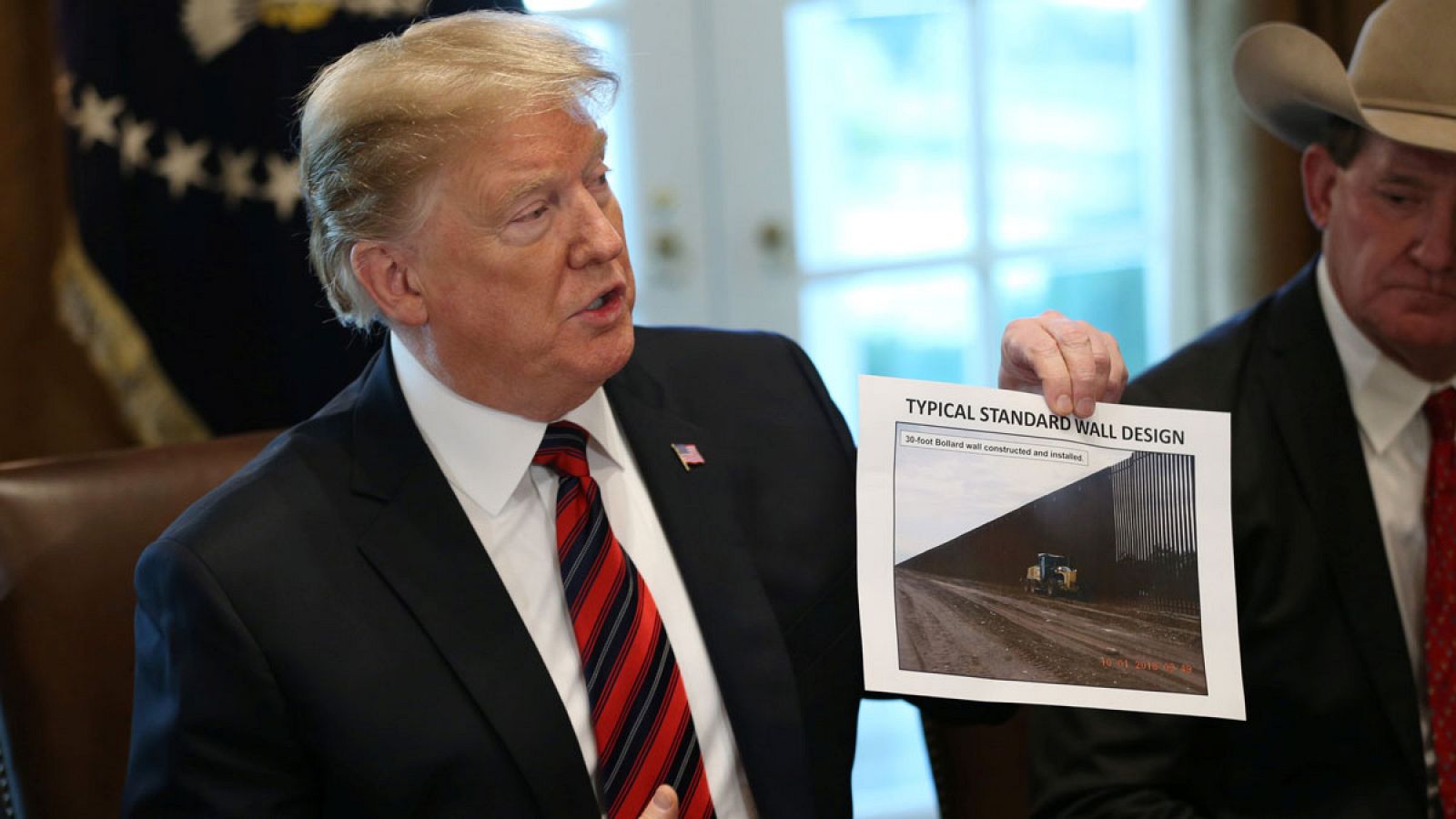 El presidente de los Estados Unidos, Donald Trump, sosteniendo una foto con un mensaje sobre el muro durante una reunión en la Casa Blanca en Washington.