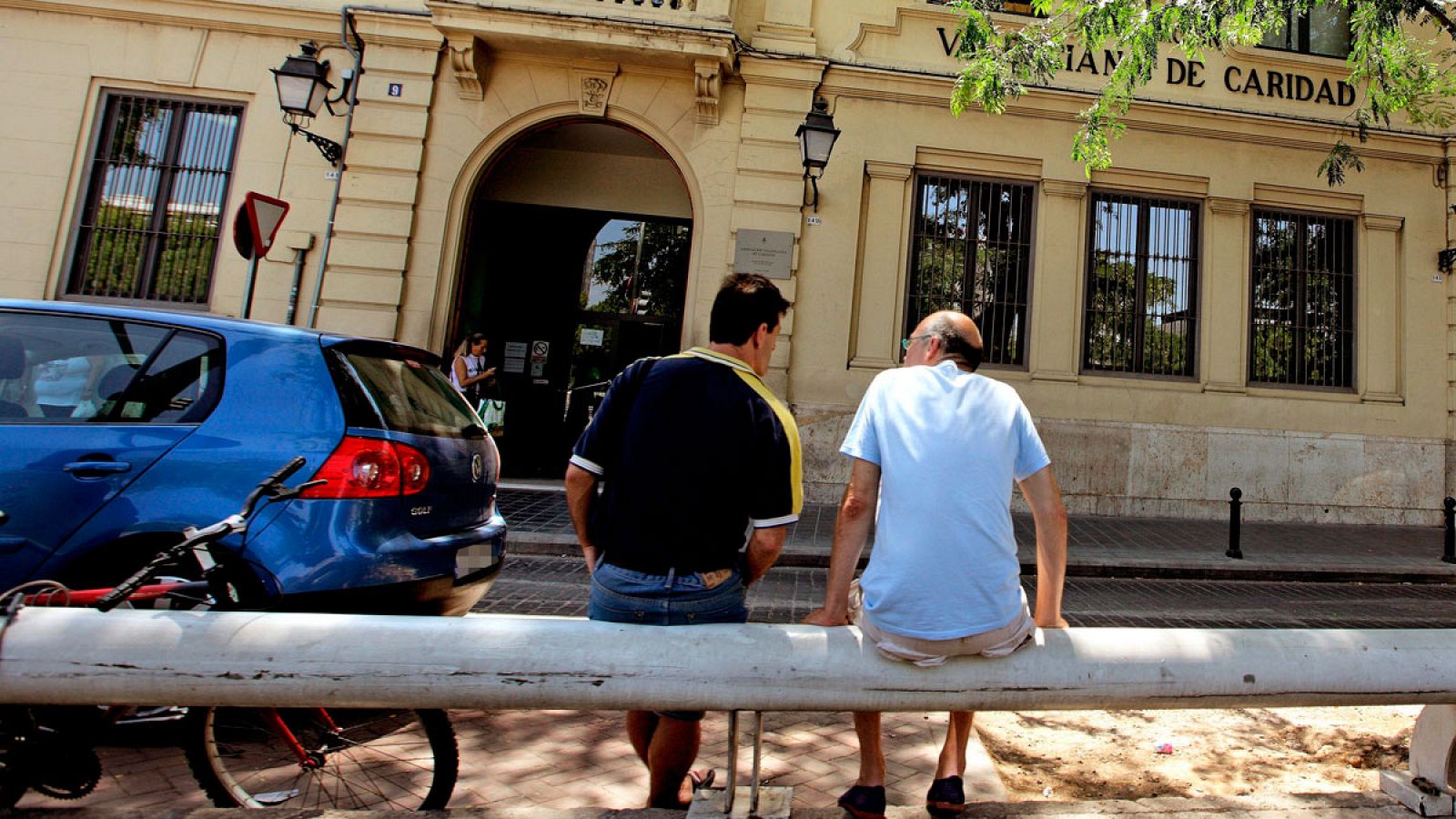 Imagen de archivo de dos hombres sentados ante la Casa de la Caridad de Valencia