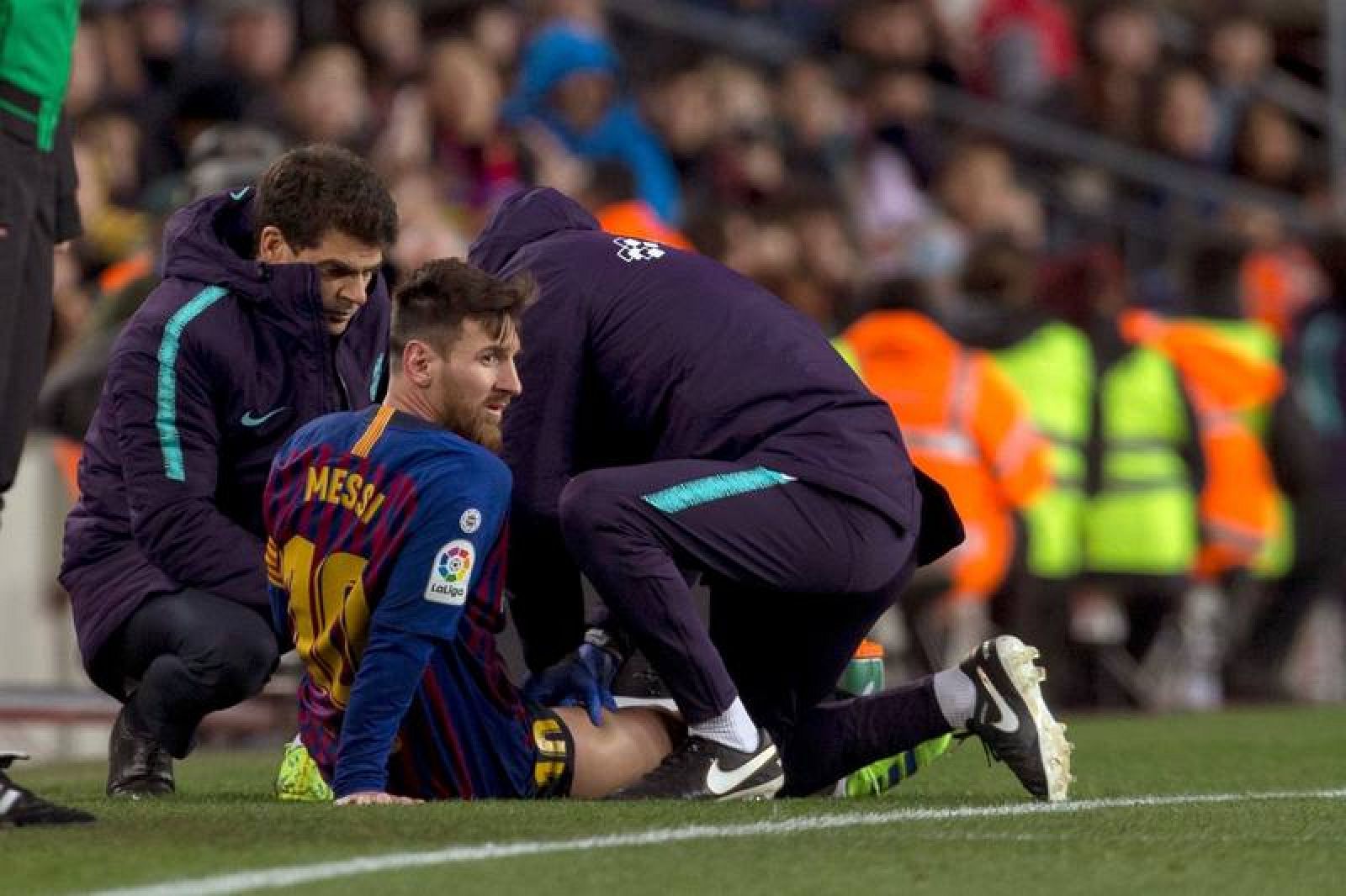 Messi, atendido por los sanitarios del Barça durante el partido ante el Valencia 