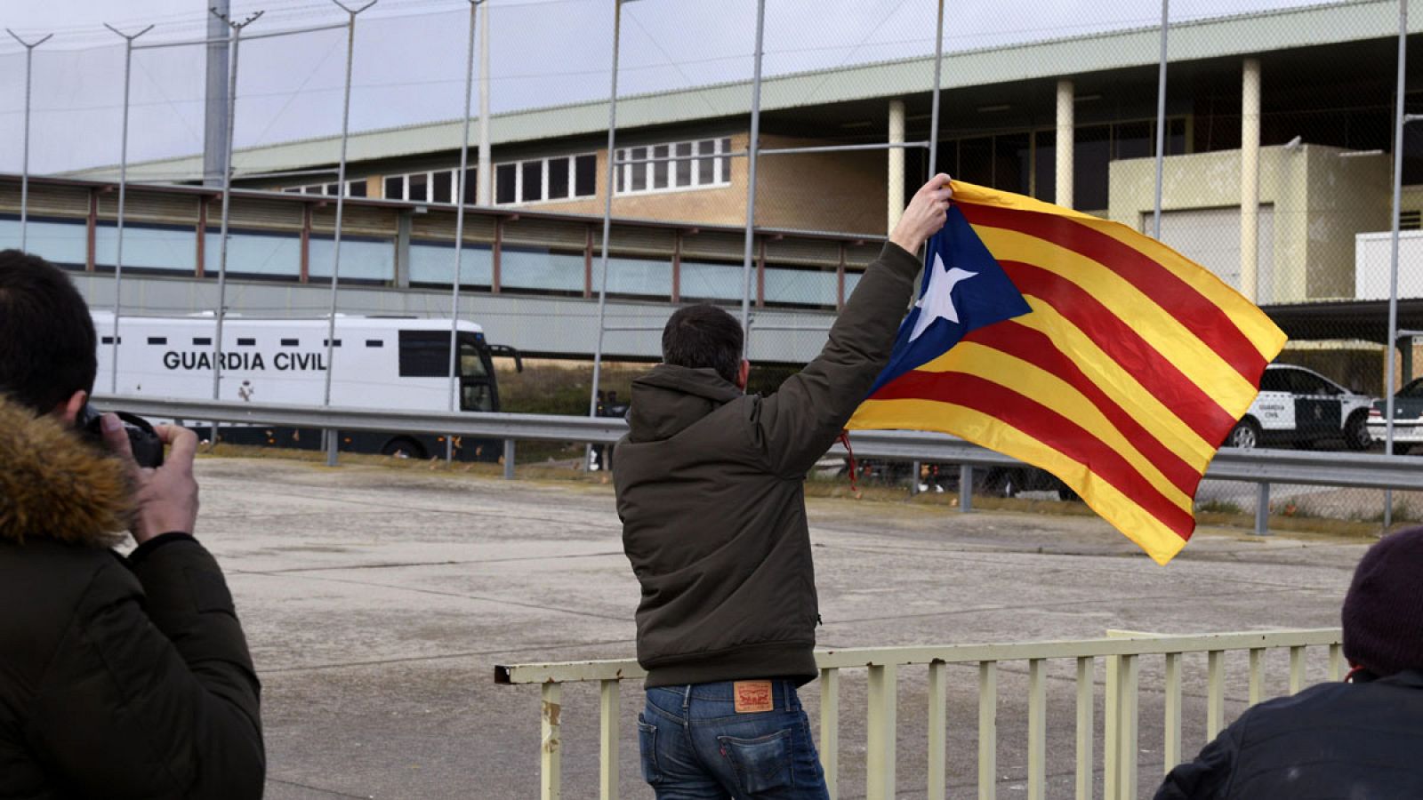 Fotografía de archivo en la que un hombre ondea una estelada a la llegada del autobús de la Guardia Civil que traslada a Oriol Junqueras, Raül Romeva, Josep Rull, Jordi Turull, Joaquim Forn, Jordi Cuixart y Jordi Sànchez, a la cárcel de Soto del Real