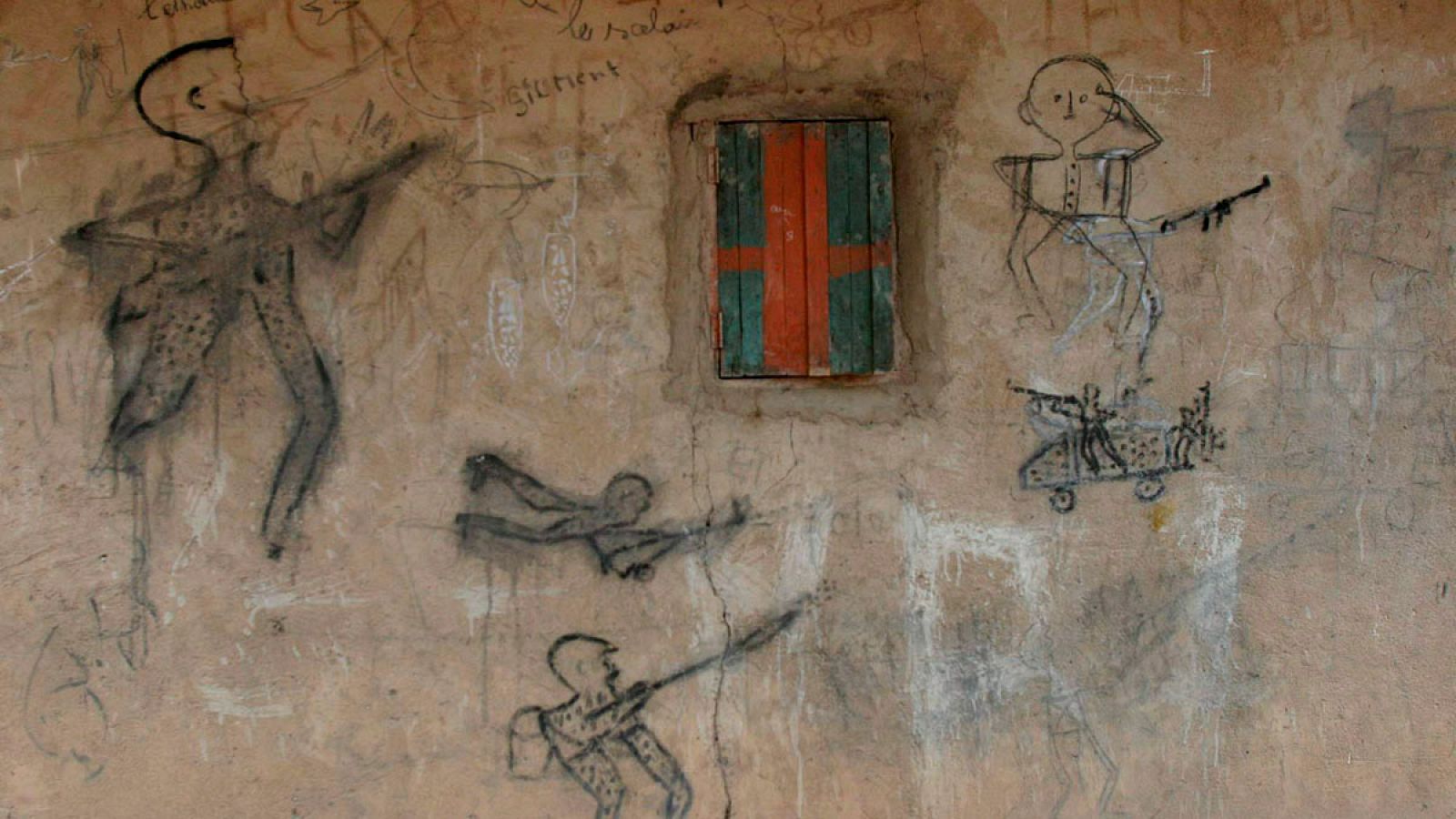 Dibujos hechos sobre un muro de una casa que representan a hombres armados disparando en el poblado de Beboura, al norte de la República Centroafricana.