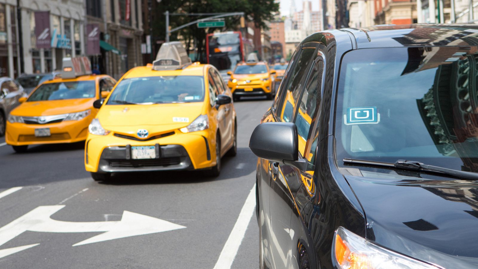 Un coche de Uber circulando junto a varios taxis en Manhattan, Nueva York