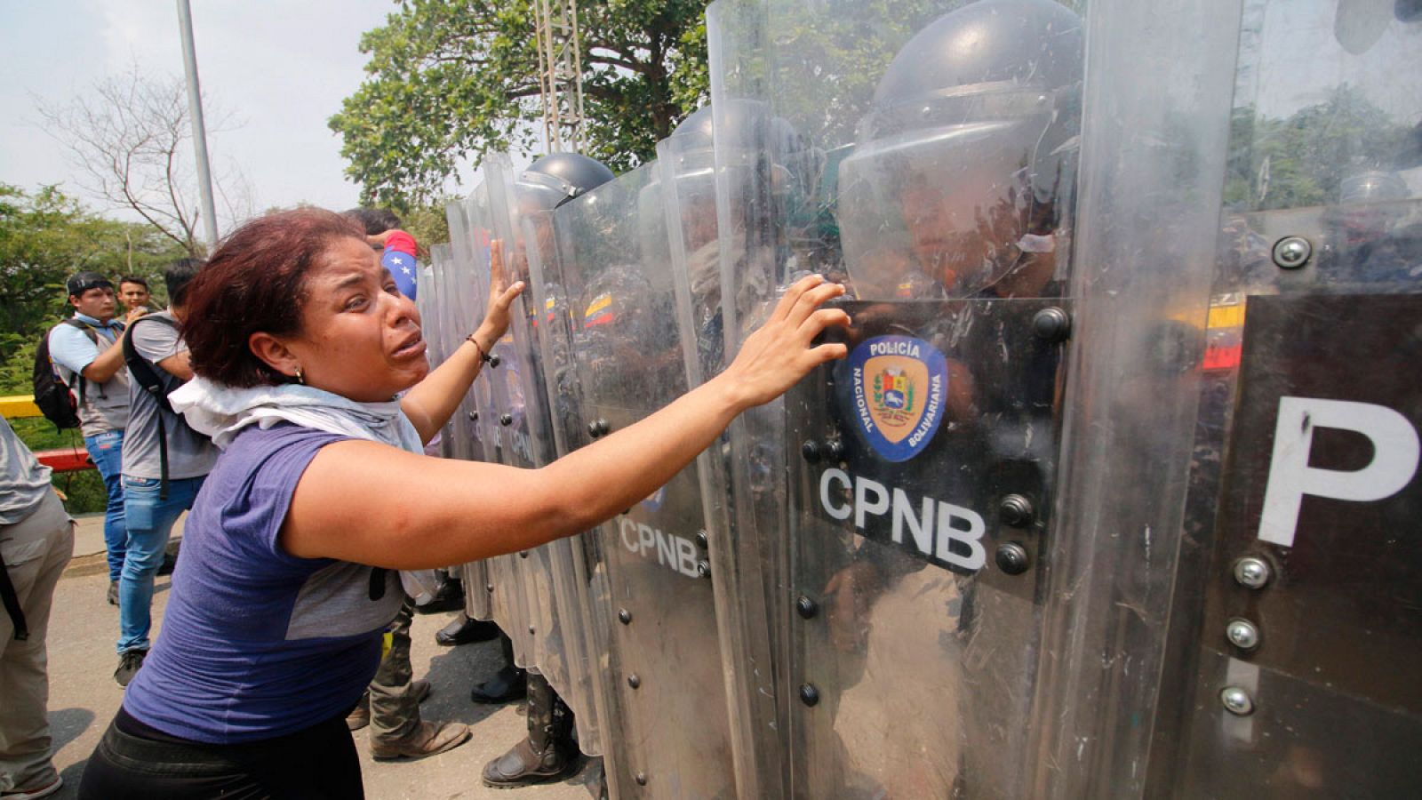 Una mujer muestra su desesperación ante el bloqueo de la policía venezolana al paso de la ayuda humanitaria