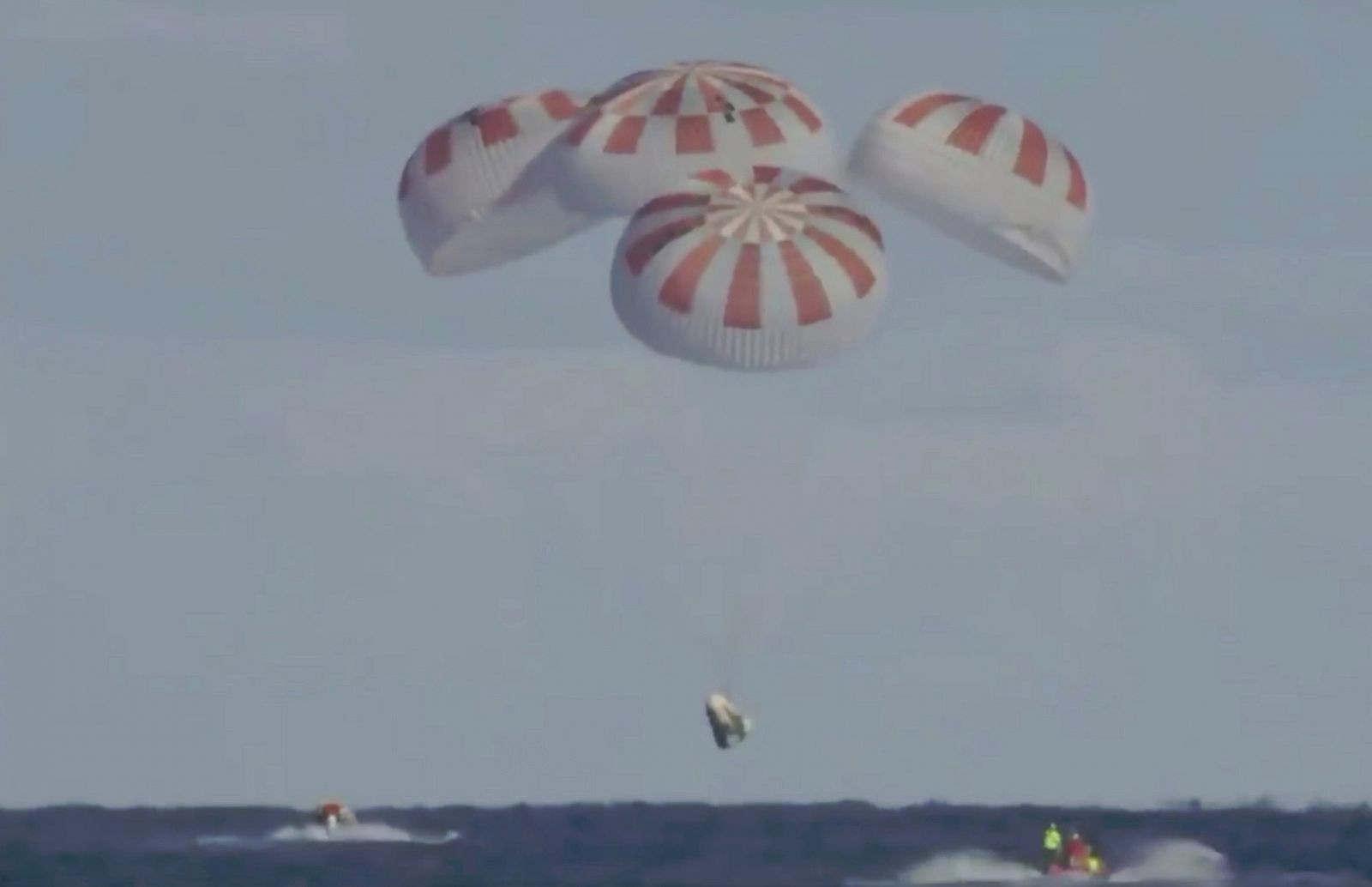 Imagen de la Crew Dragon, a punto de posarse en las aguas de Florida con la ayuda de cuatro paracaídas.