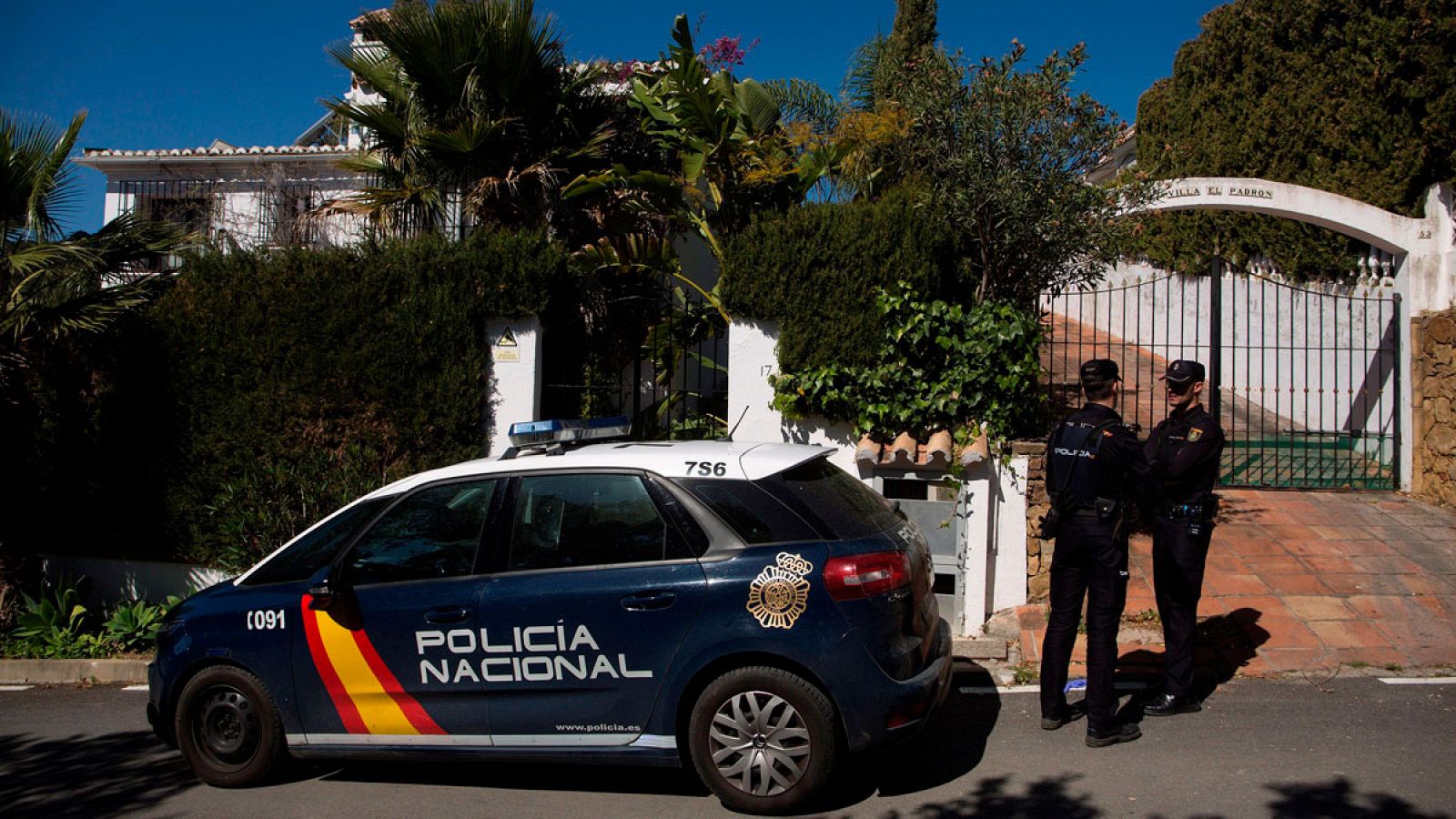 Dos miembros de la Policía Nacional custodian la vivienda donde una mujer de 58 años y nacionalidad española fue asesinada presuntamente por su marido