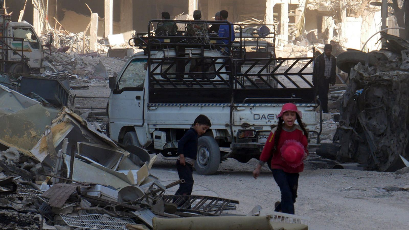 Imagen de archivo de unos niños caminando entre los escombros de edificios destruidos en la ciudad de Harasta, en Guta Oriental (Siria).