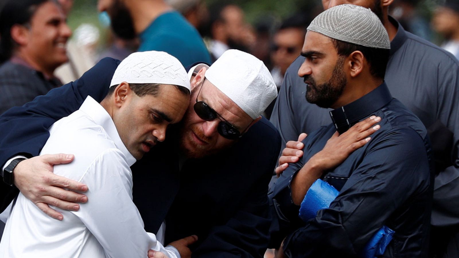 Imagen de varias personas consolándose en el exterior de la mezquita de Al Noor en Christchurch, Nueva Zelanda.