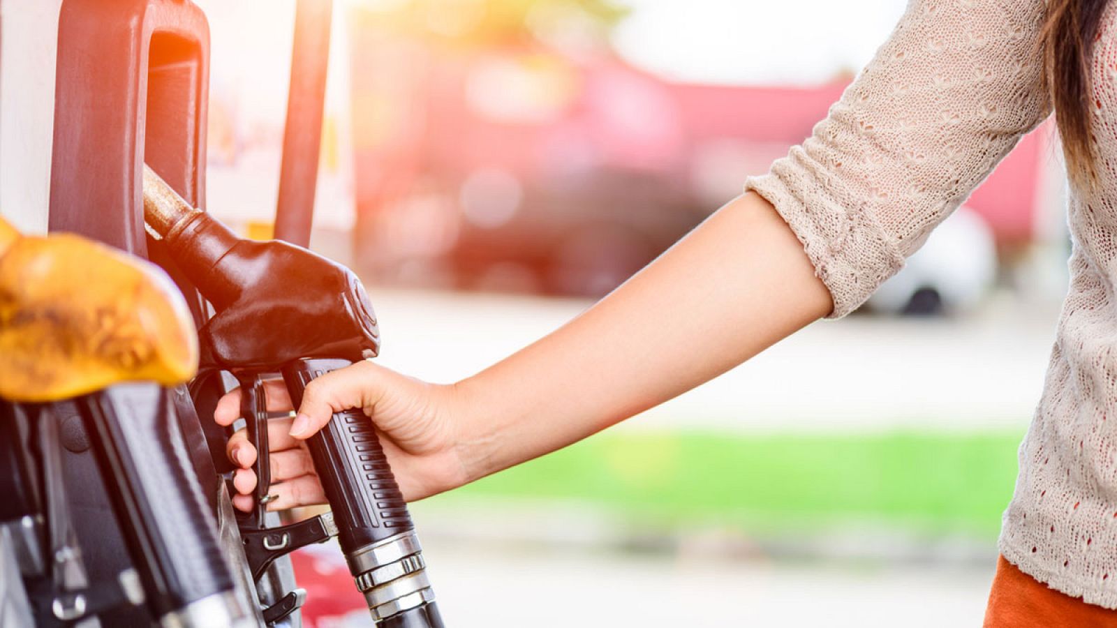 Una mujer reposta combustible en una gasolinera