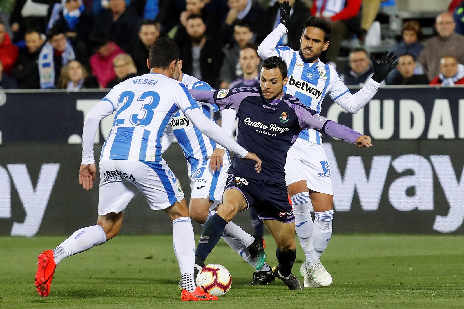 El centrocampista del Real Valladolid, Óscar Plano (c), pelea un balón con Mikel Vesga (i) y José Luis "Recio" (d), ambos del Leganés, durante el partido de LaLiga que se disputa esta noche en el estadio de Butarque.