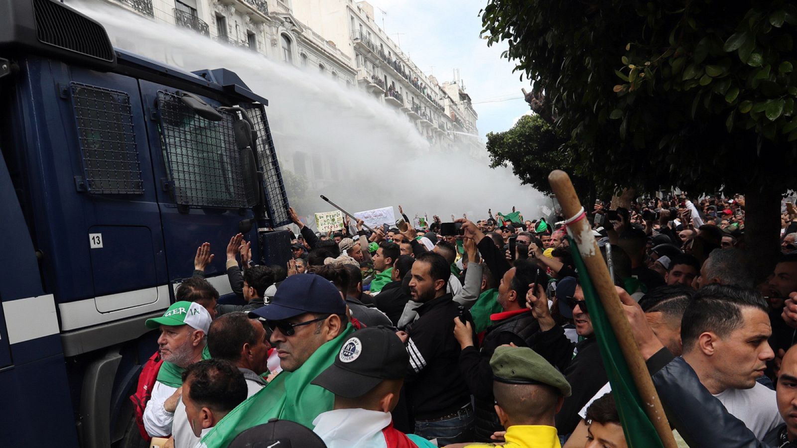 Un camión con un cañón de agua intenta dispersar a los manifestantes durante una protesta contra el presidente interino, Abdelkader Bensalah, en Argel