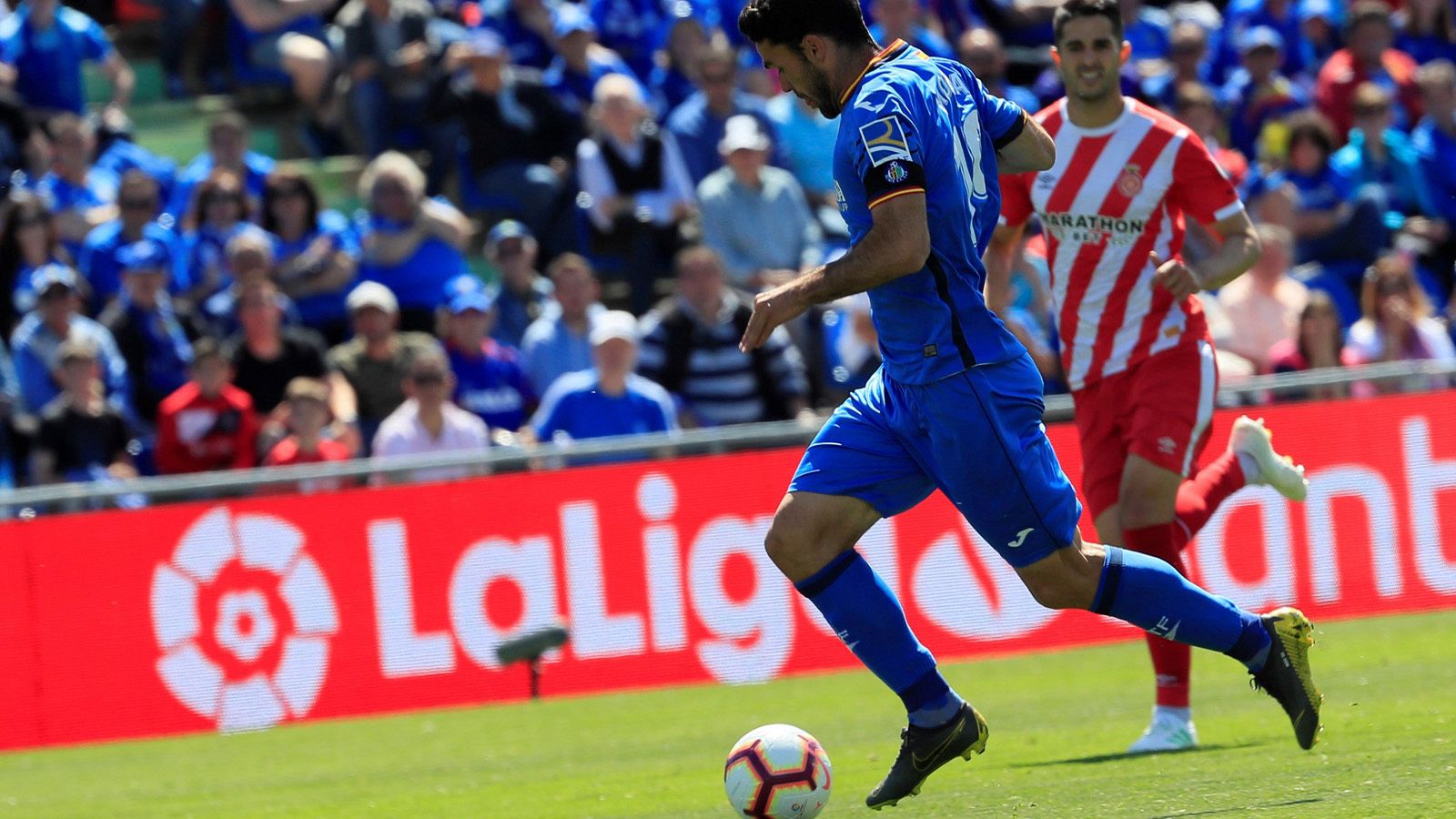 El delantero del Getafe Jorge Molina (i) controla el balón ante un defensor del Girona