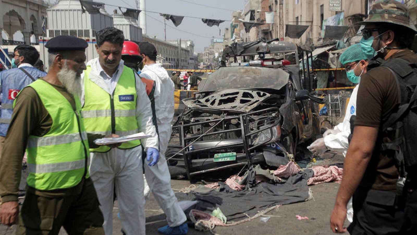 Artificieros y sanitarios examinan el lugar de la explosión en Lahore