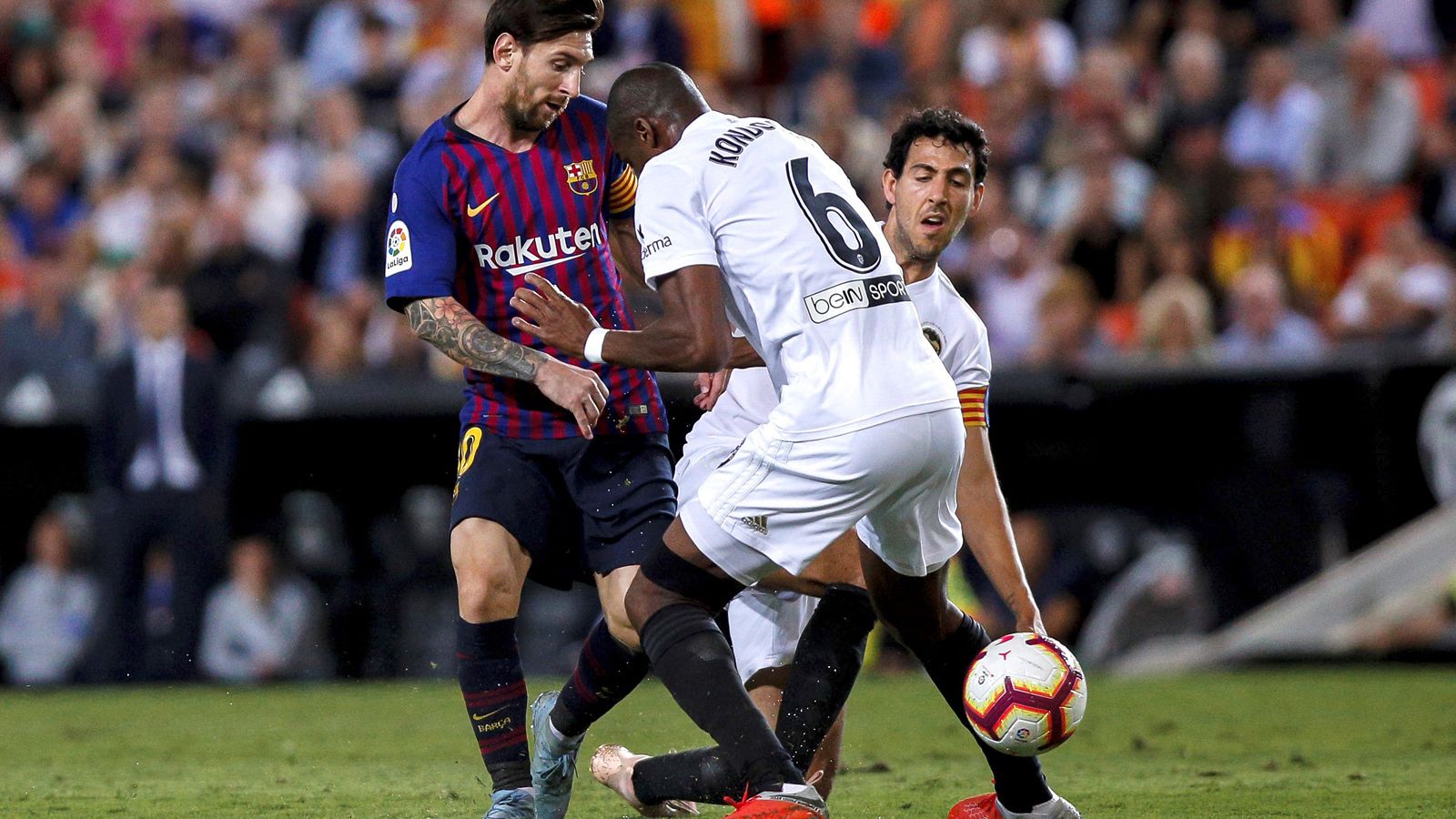 Messi encara a Kongdobia, ante la presencia de Parejo, durante el partido de la primera vuelta de la Liga en Mestalla