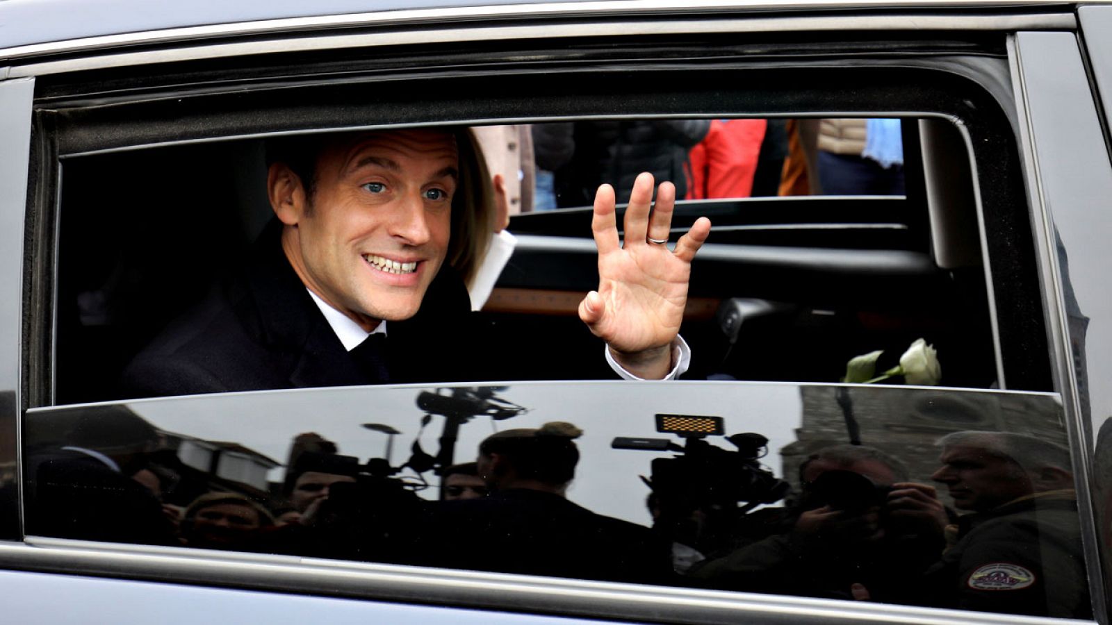 El presidente francés, Emmanuel Macron, saluda desde el coche oficial tras votar en las elecciones europeas