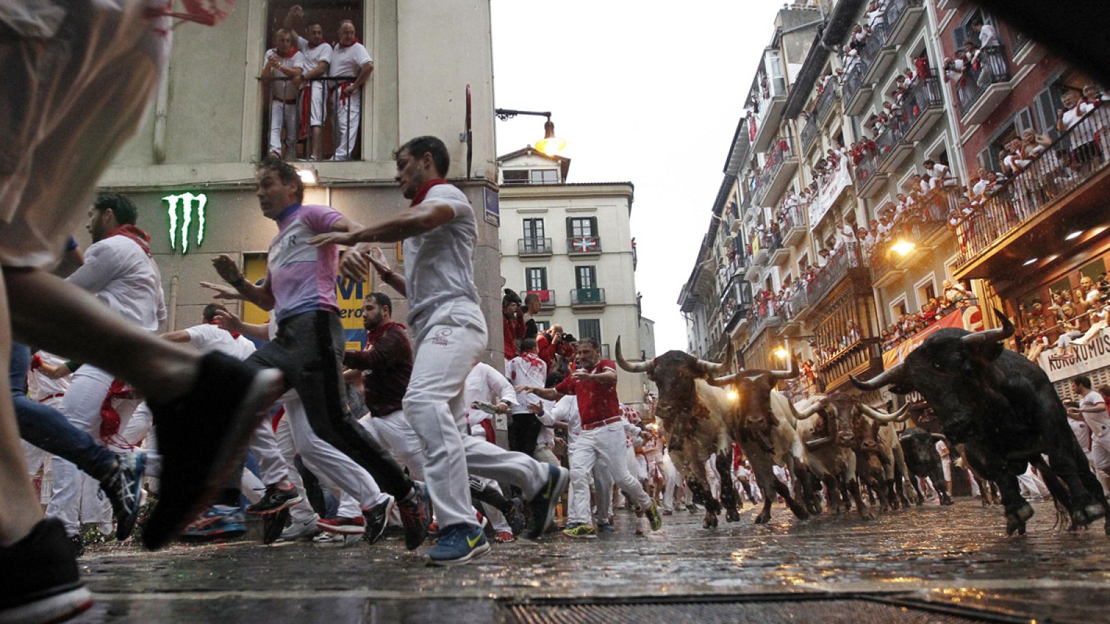 Corredores y toros, durante un encierro de Sanfermines