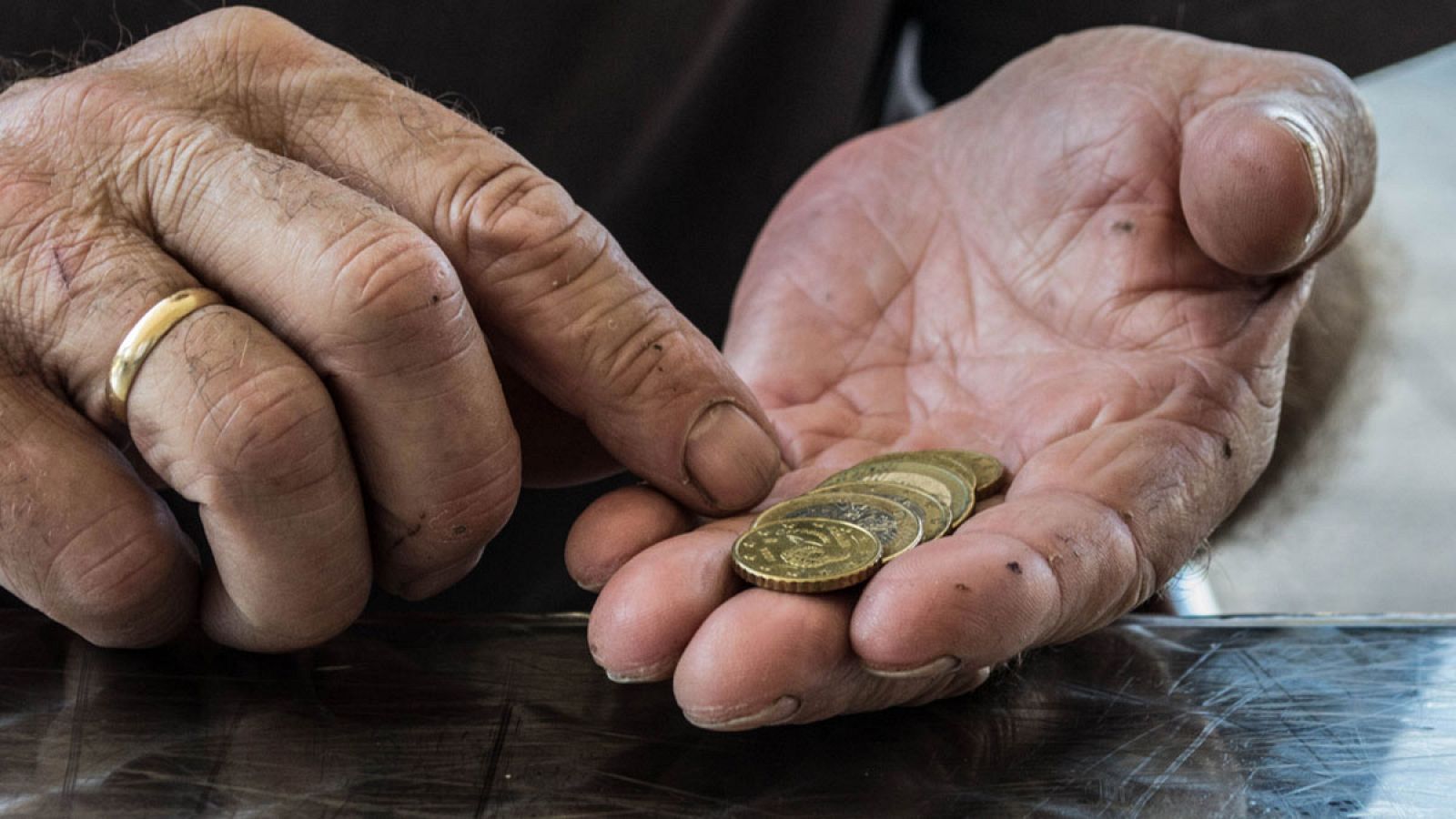 Un jubilado cuenta unas monedas