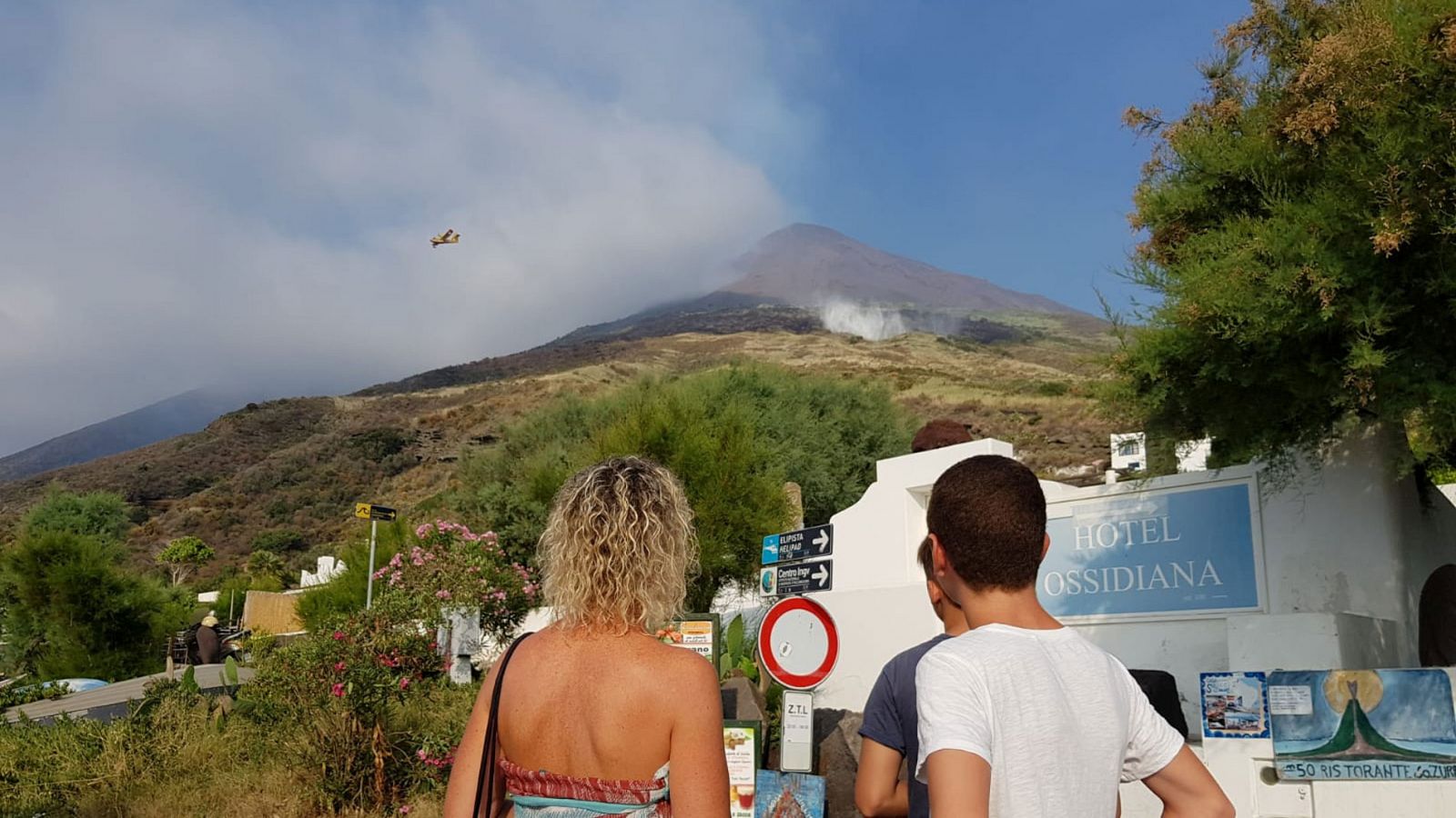 Dos turistas observan la actividad del volcán Estrómboli, un día después de la erupción