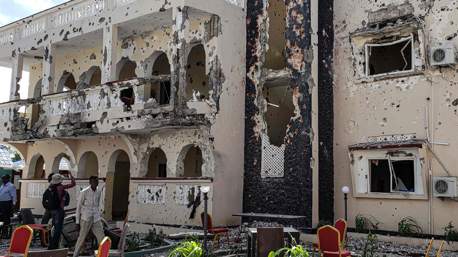 Un hombre pasa frente a los escombros del popular hotel Medina de Kismayo tras el atentado terrorista que ha dejado al menos 26 muertos.