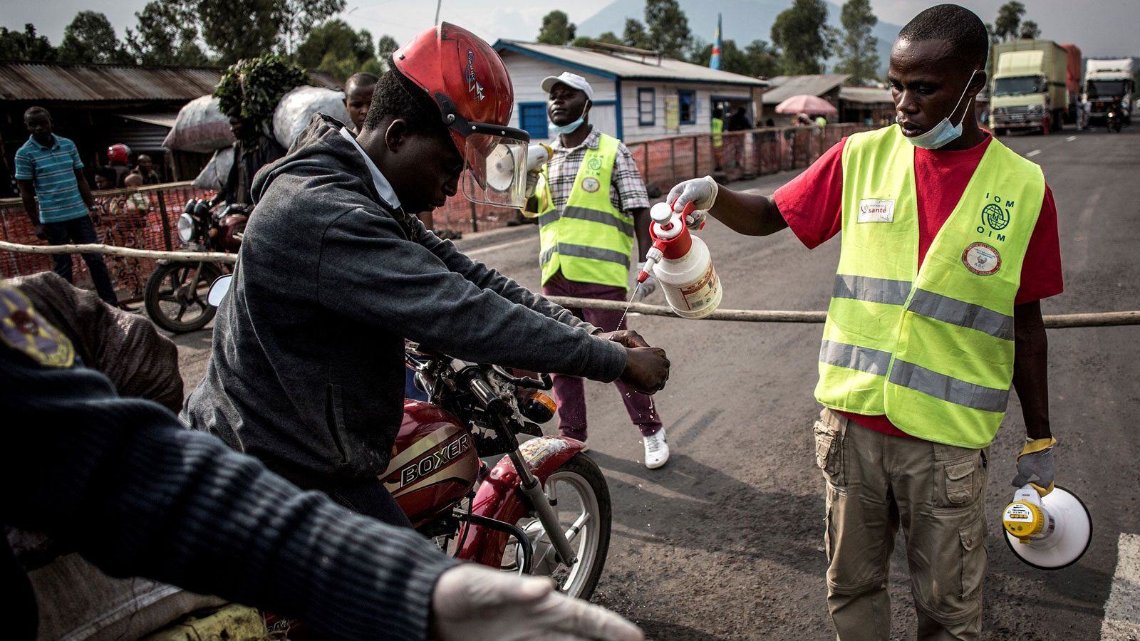 Un conductor se lava las manos en una estación de detección de ébola en la carretera entre Butembo y Goma