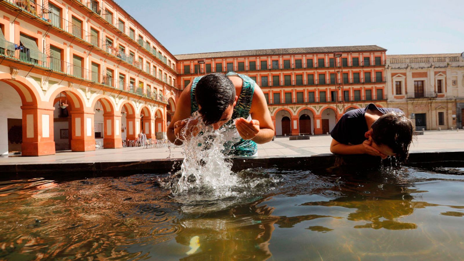 Unos niños se refrescan en una fuente de la Plaza de La Corredera de Córdoba