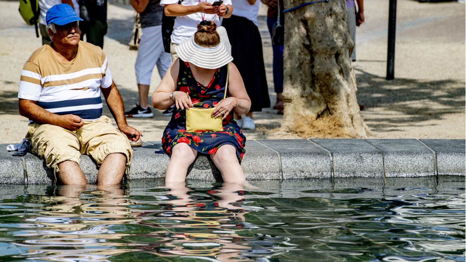 Dos personas se refrescan en una fuente para soportar la ola de calor en Ámsterdam. Países como Francia, Reino Unido y Alemania han batido el récord de temperaturas este jueves. 