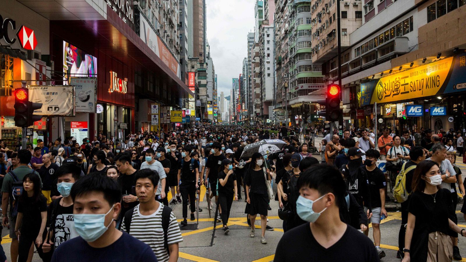Los manifestantes recorren una calle comercial de Hong Kong